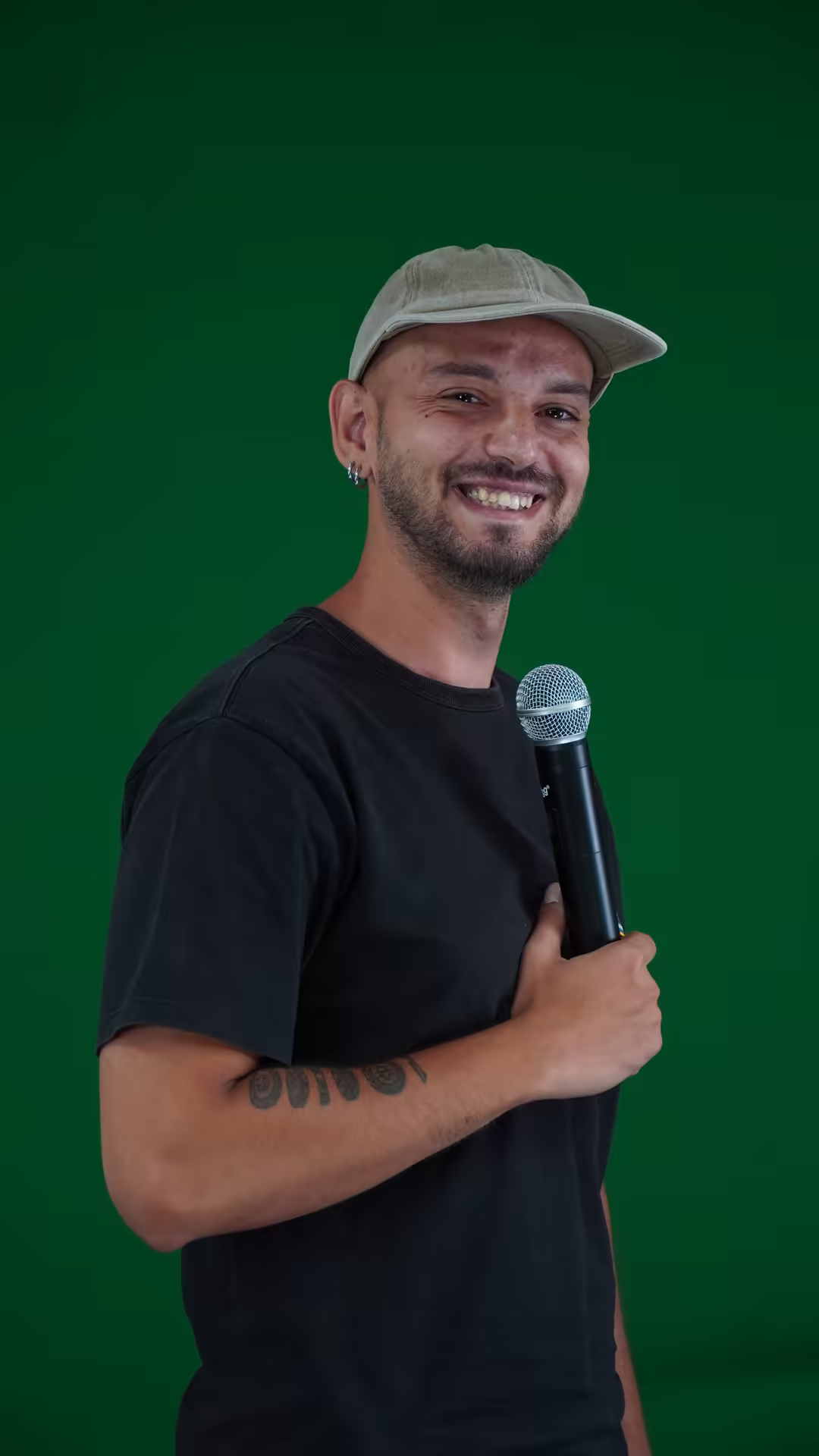 Marin Marinov smiling with a microphone against a green backdrop