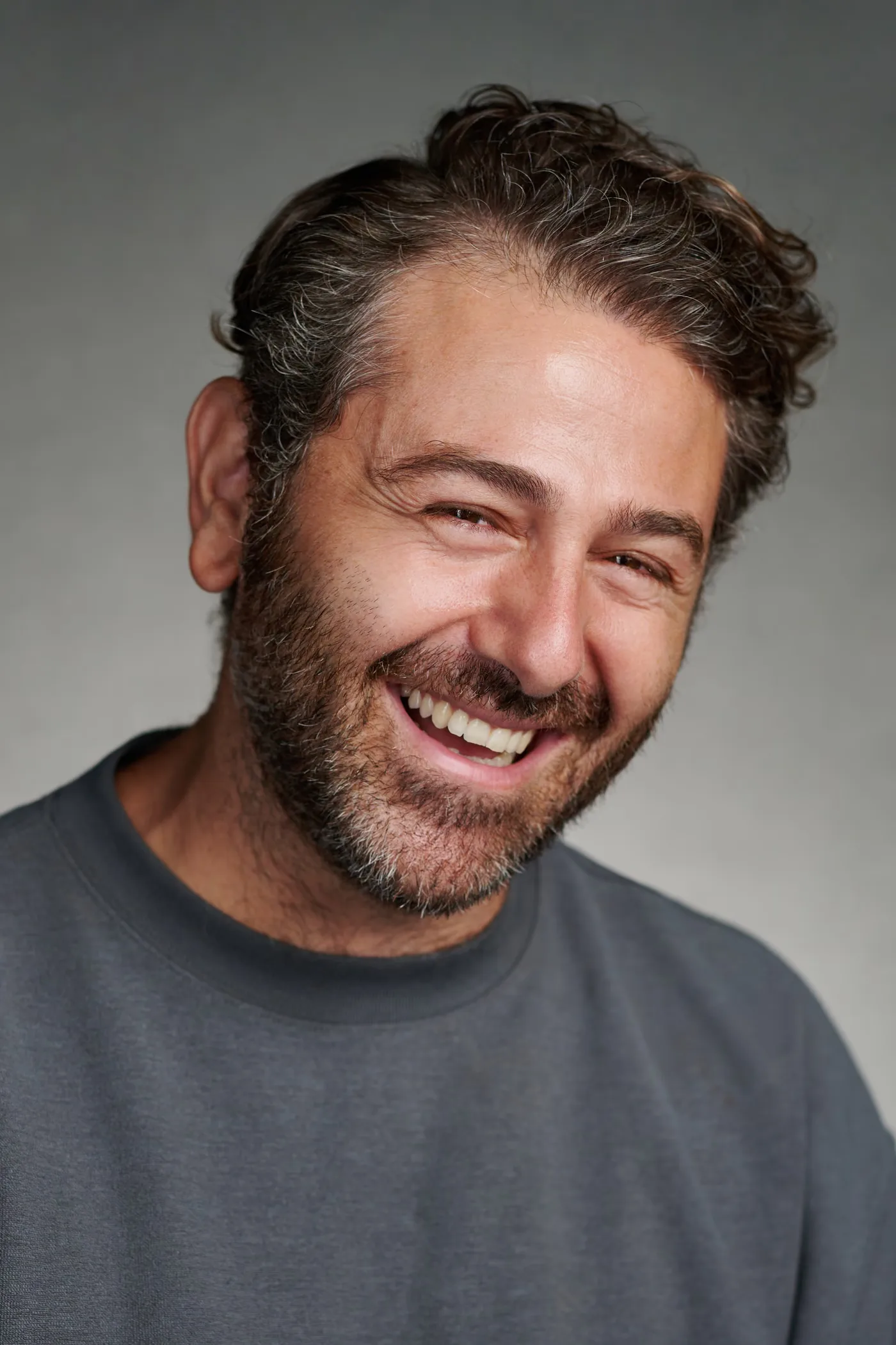 Close-up studio portrait of Yorkos laughing